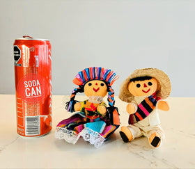 ALKIMIA INC Maria doll with braided hair and ribbons complements a partner.
