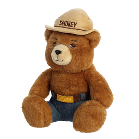 Aurora Smokey Bear plush in woodland decor setting.