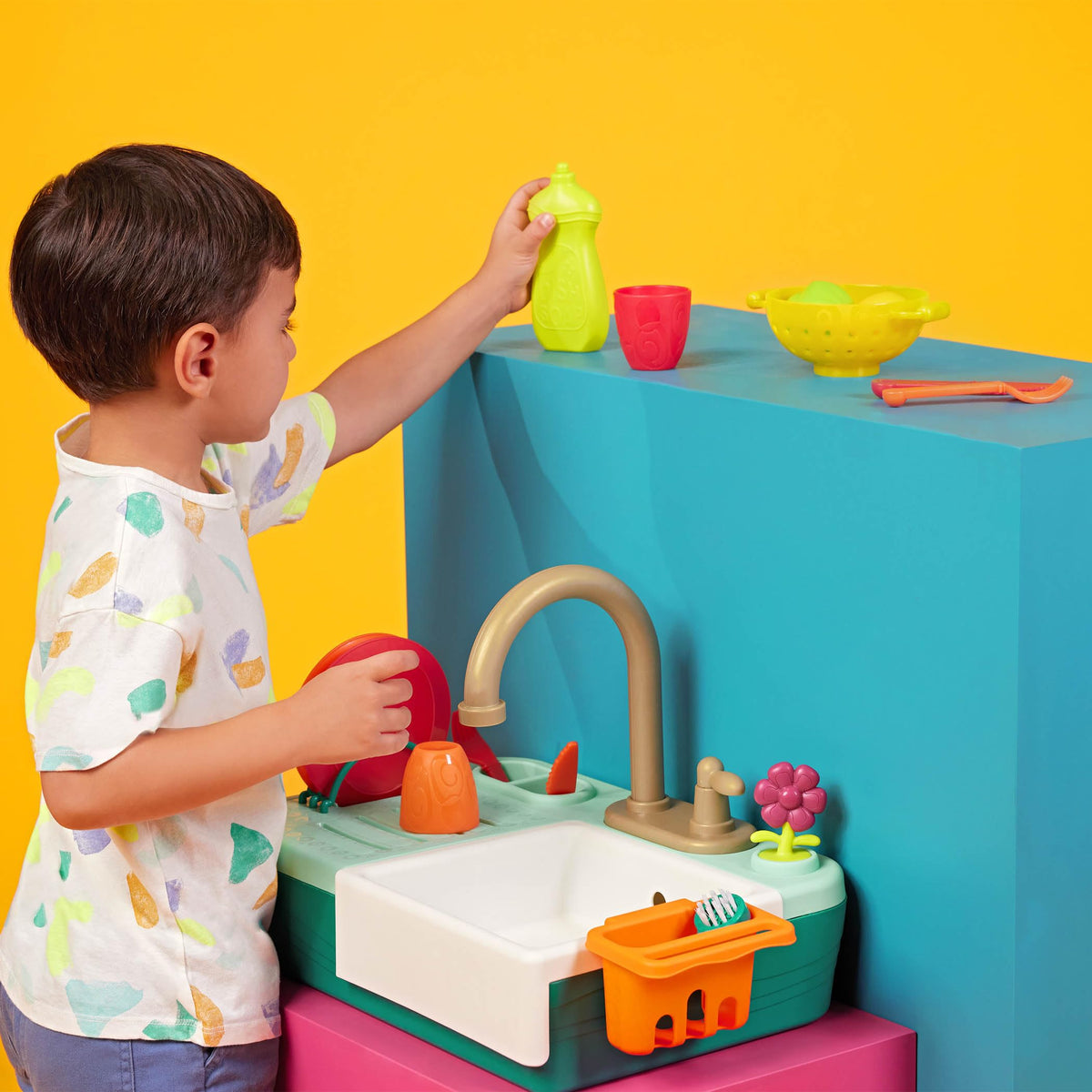 B. toys Splash-n-Scrub Sink dish rack helps tidy up after pretend meals.