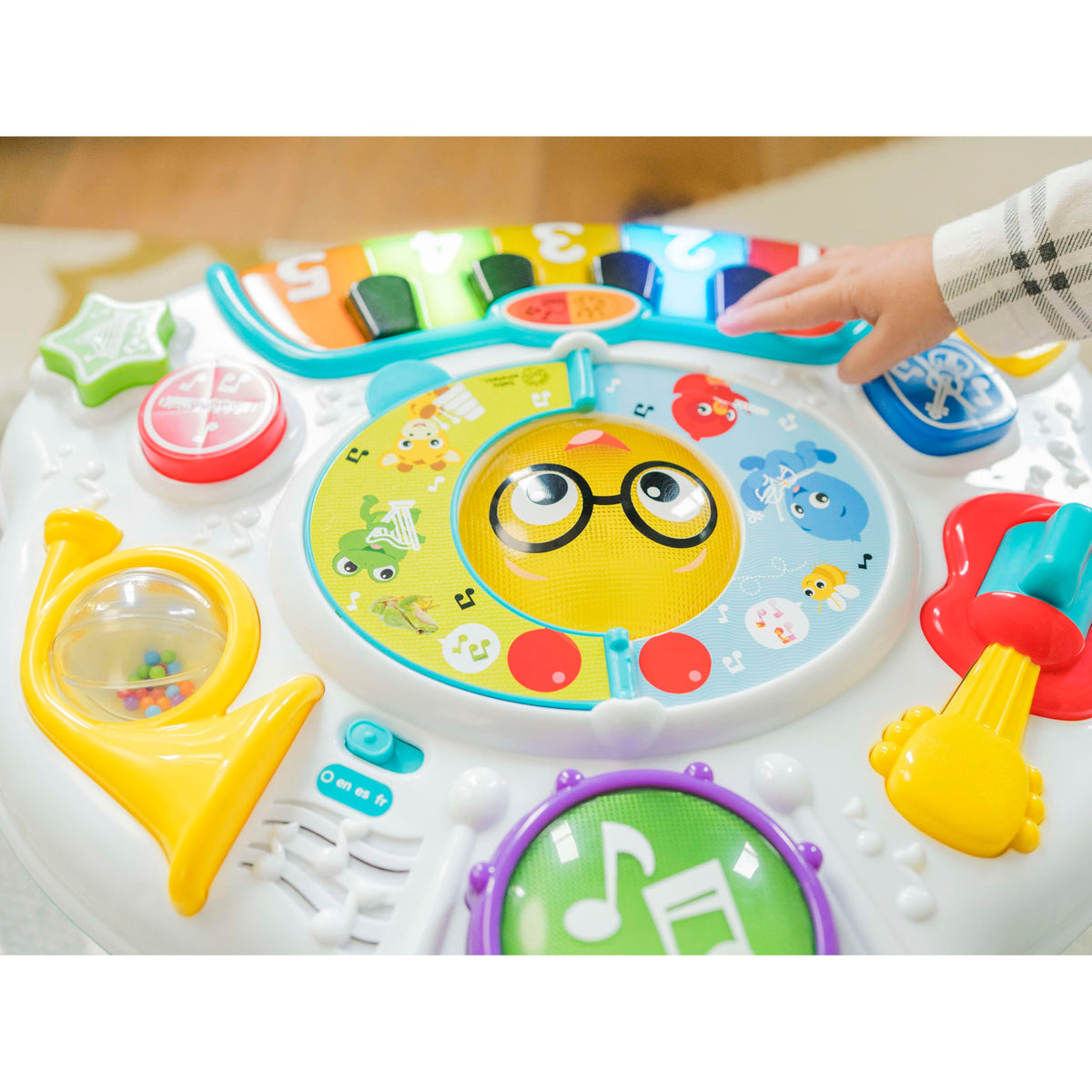 Baby Einstein Discovering Music Table music book triggers melodies and lights with page turns.