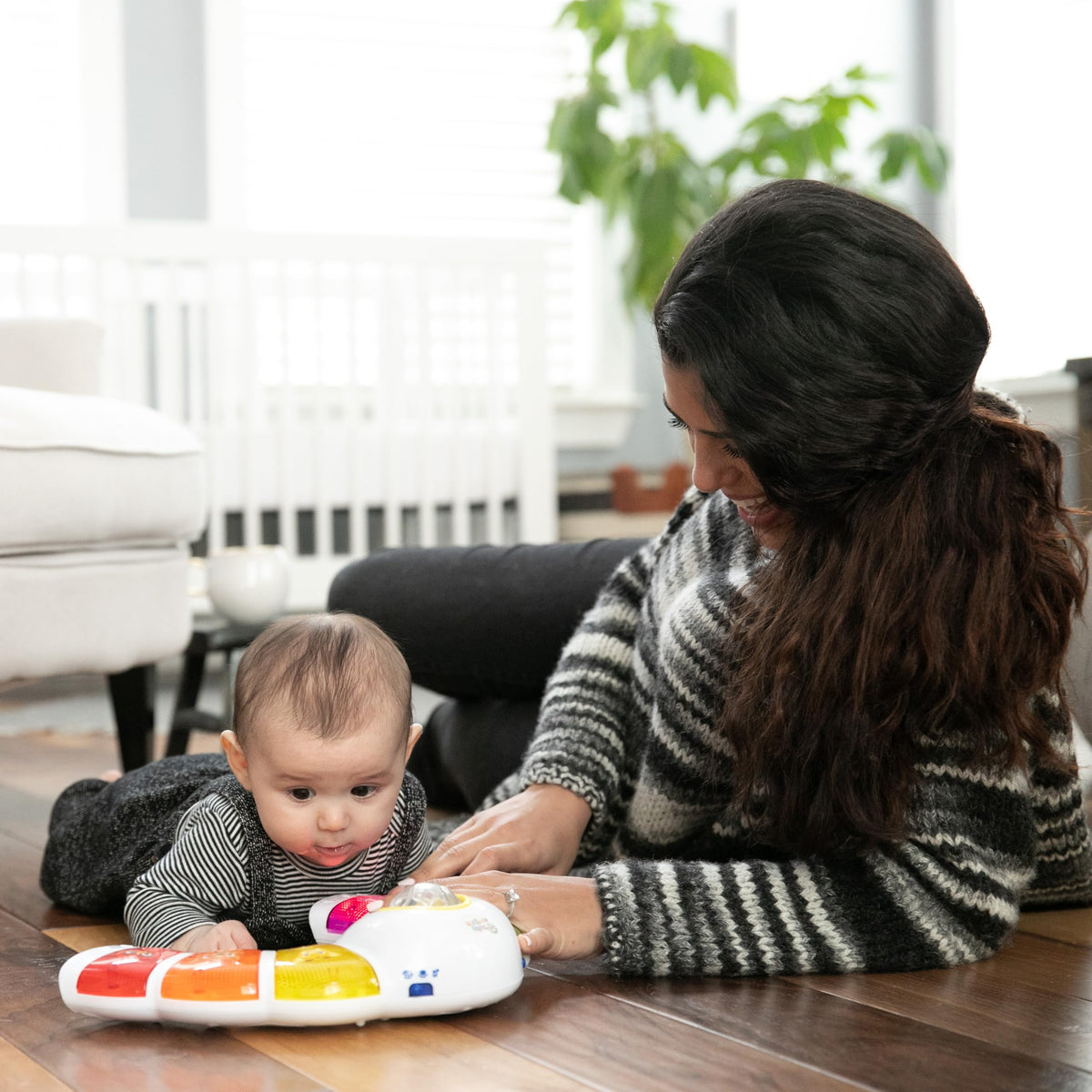 Seated play on Baby Einstein Glow & Discover invites pressing buttons and spinning the drum.