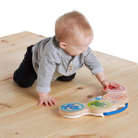 Close-up of baby tapping the Magic Touch sensor for responsive play.