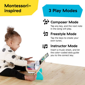 Toddler sits at a bench playing the Baby Einstein Magic Touch Piano