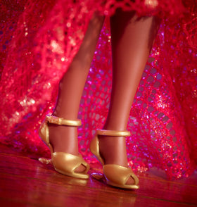Barbie Celia Cruz doll stand supports elegant display.