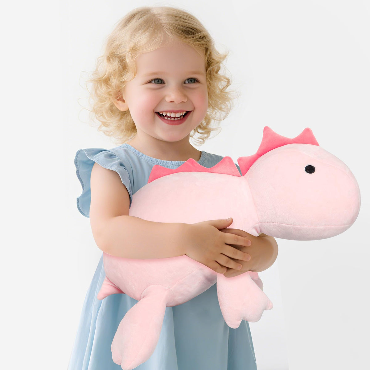 BestVive pink weighted dino plush used as decorative bed decor.