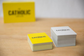 Packaging showcases The Catholic Card Game setup and design.