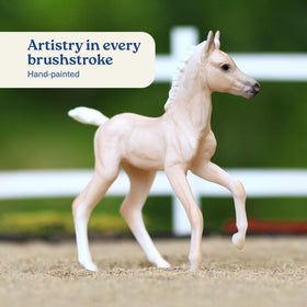 Breyer Palomino foal detail highlighting playful companionship on shelves.