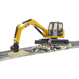Bruder 02457 CAT mini excavator front-blade leveling for stable ground play.