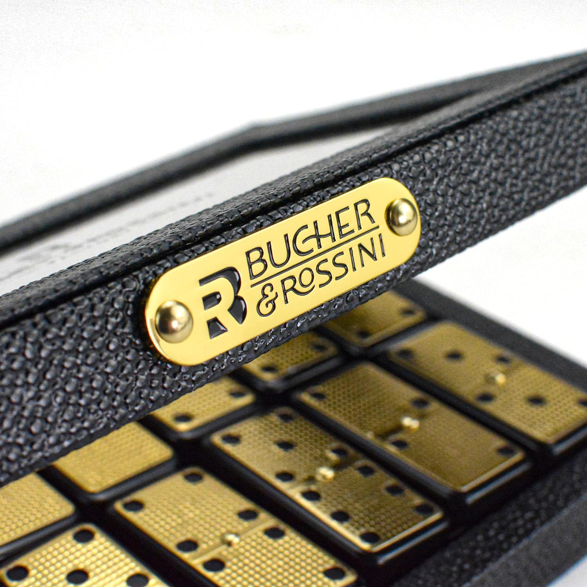 Bucher&Rossini double-six dominoes with gold finish on table during game