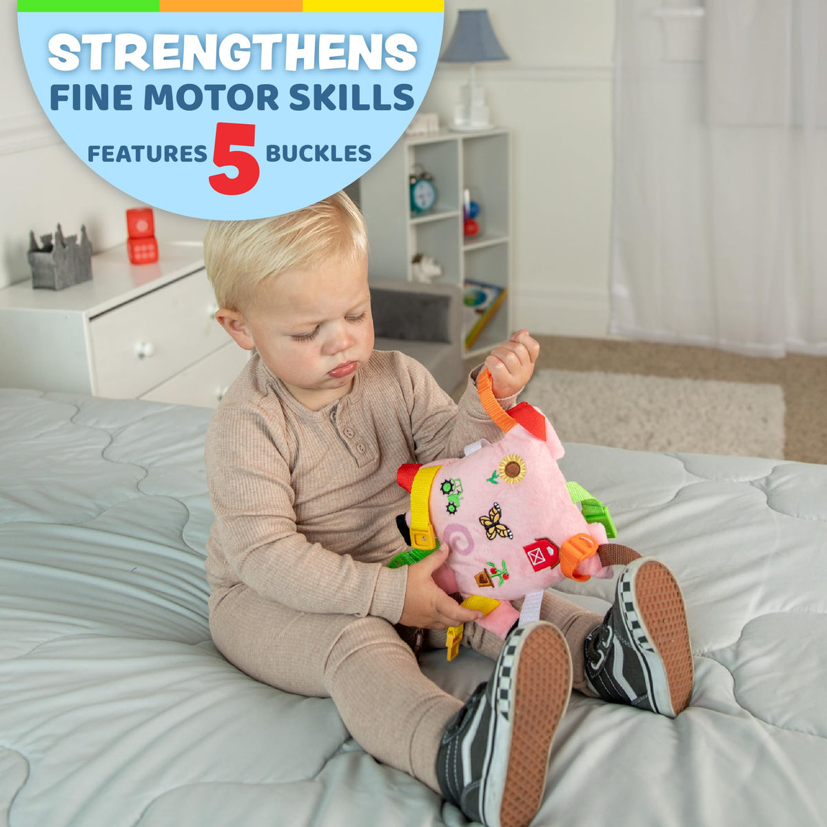 Buckle Toys Boink Pig with colorful straps encourages hands-on exploration.