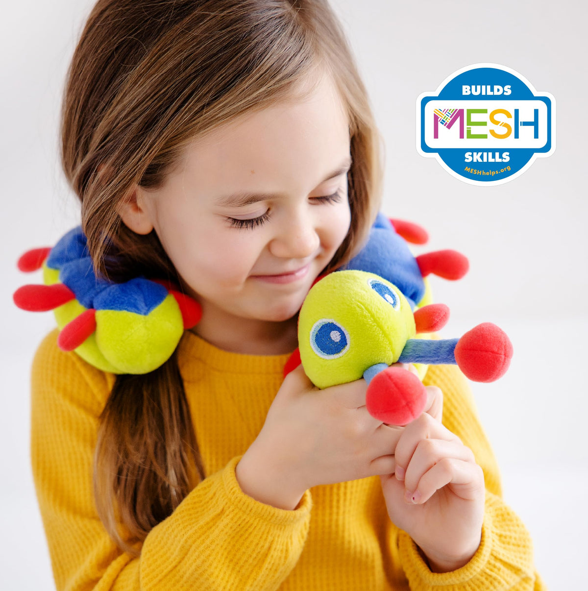 Child hugging Calmee the Caterpillar for a calm, focused moment.