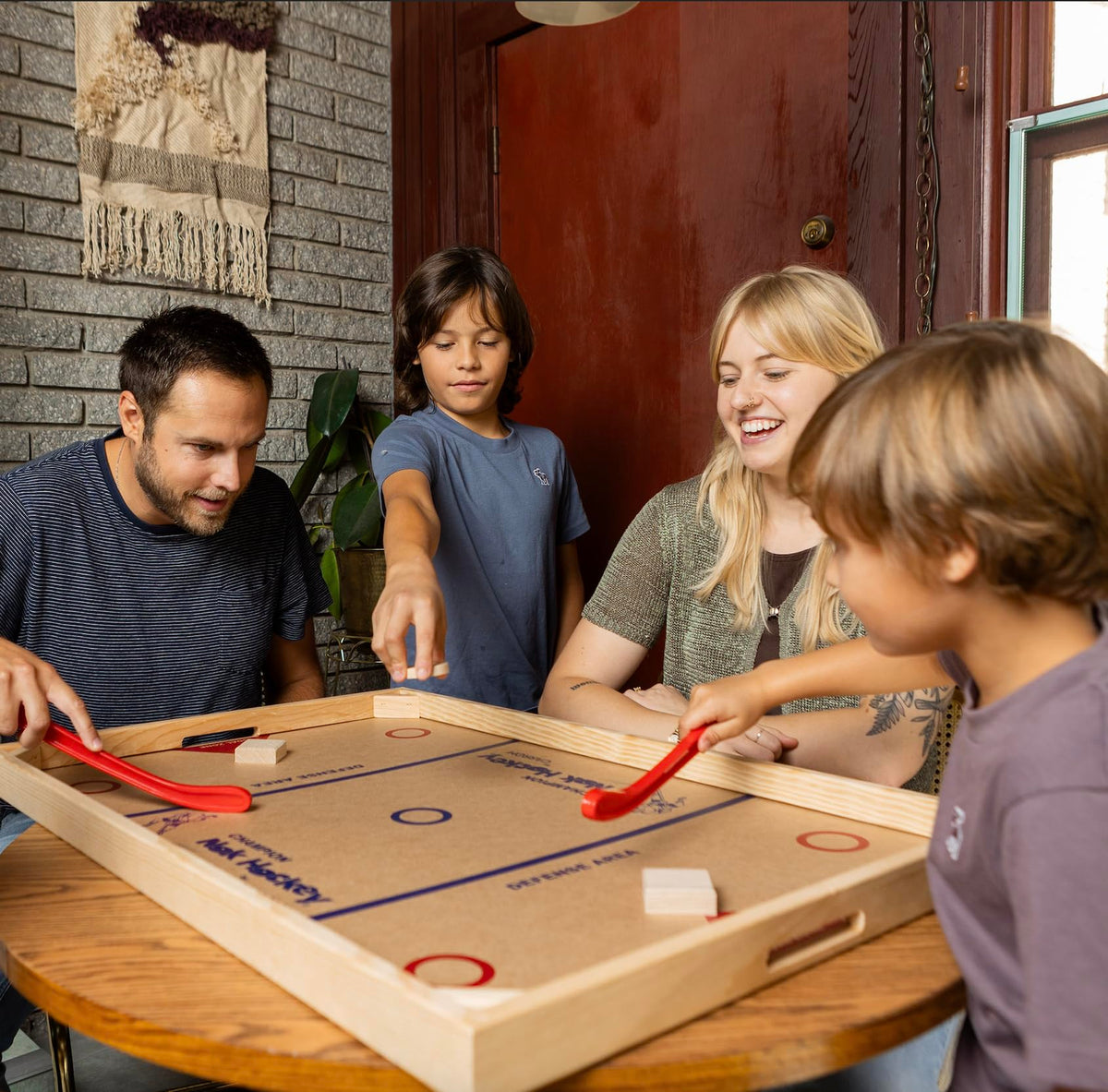 Carrom Champion Nok Hockey Game sticks and pucks in action on a wood table