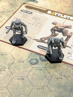 BattleTech Beginner Box components layout showing two Mech miniatures and dice for starter games