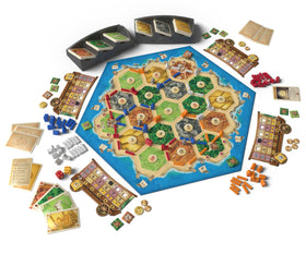 CATAN Traders and Barbarians expansion components in hand, showcasing strategic planning