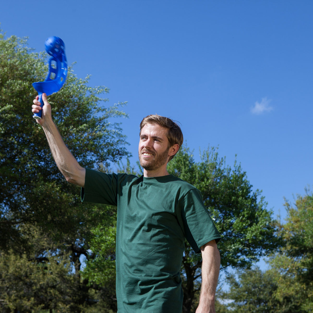 Champion Sports family playing scoop ball in sunny backyard