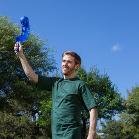 Champion Sports family playing scoop ball in sunny backyard
