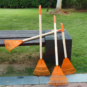 Child using CheerBank rake in garden showing safe ergonomic grip
