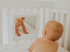 Cribby mirror shows infant’s reflection during tummy time for visual engagement.