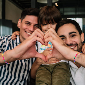 Cunno pride bracelet worn on the wrist at a festival or event.