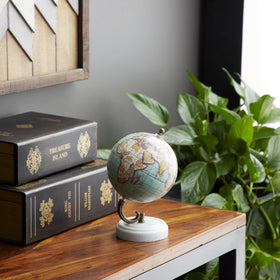 White marble base provides a refined foundation for the globe.