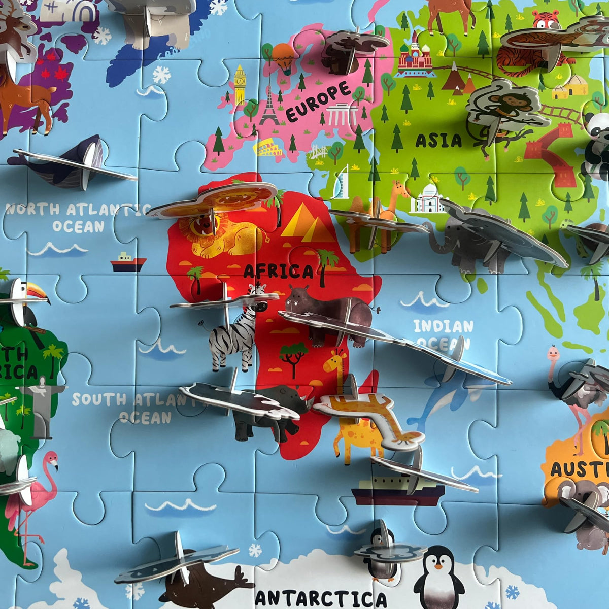Vibrant hand-illustrated world map artwork on the Dinomini puzzle sparks curiosity.