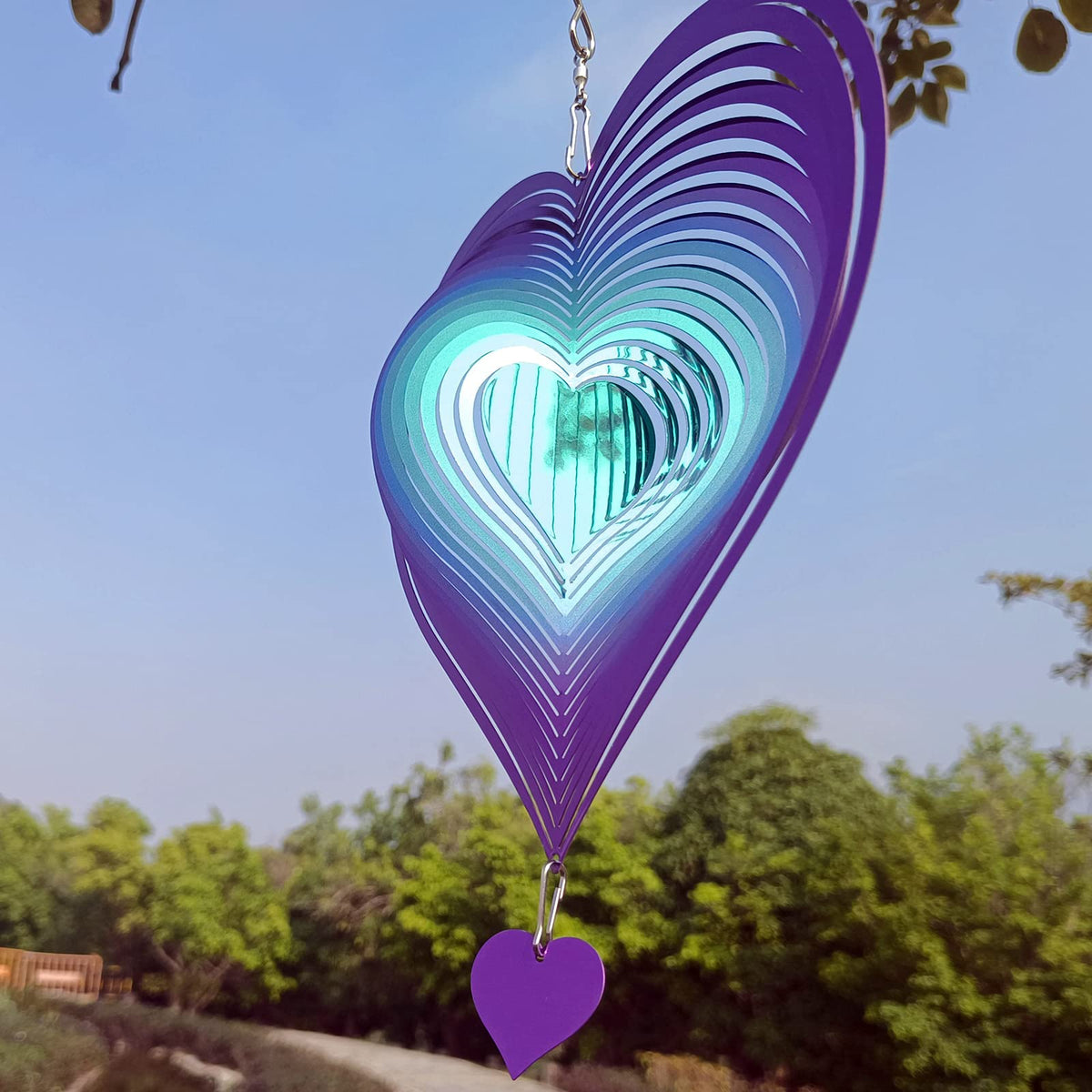 DJUAN 3D heart sculpture sparkling under sunlight, a vivid garden focal point.