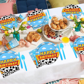 Domment cow-cloud tableware close-up: charming theme accents enhance party decor.