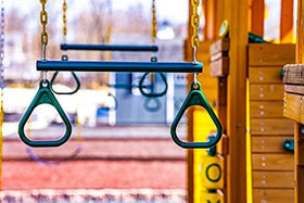 Child enjoying the Eastern Jungle Gym trapeze swing for active play