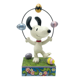 Enesco Snoopy juggling Easter eggs figurine on grass, bright spring decor.
