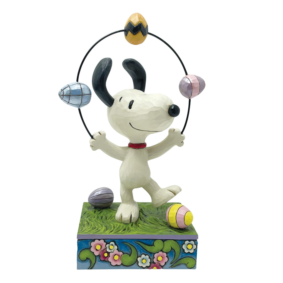 Enesco Snoopy juggling Easter eggs figurine on grass, bright spring decor.