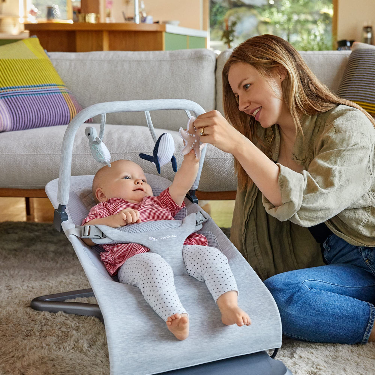 Ergobaby Evolve Toy Bar clip attaches easily to bouncer for quick setup.