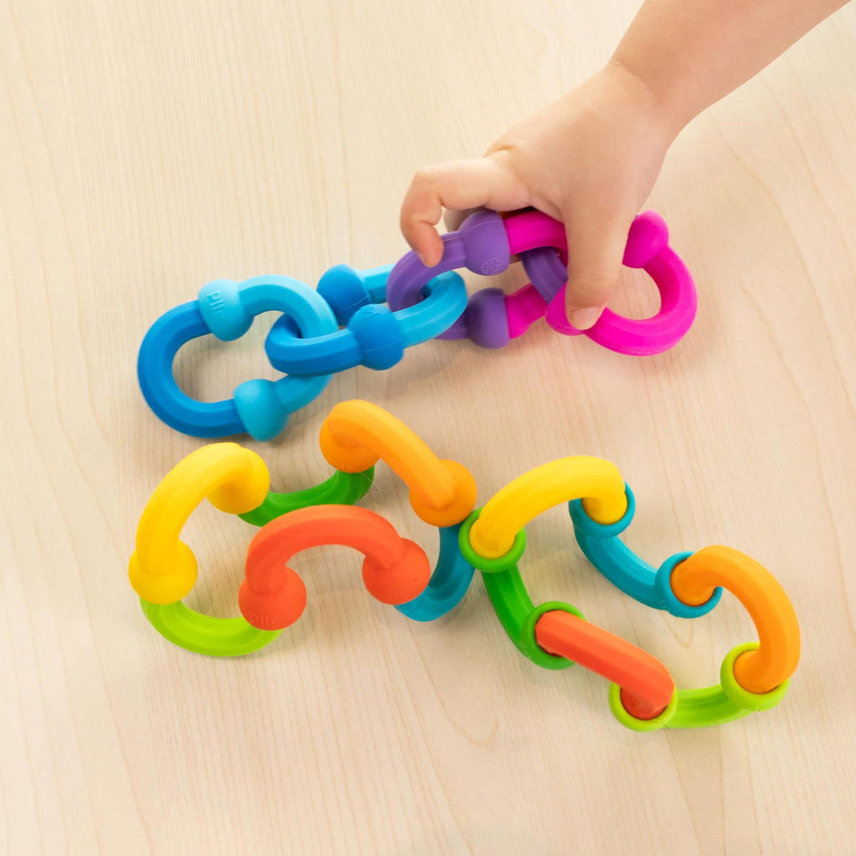 Fat Brain Toys Plip Links strengthen fine motor skills through push-and-pull play.