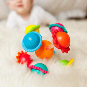 Wimzle spinning bars and spheres promote fine motor exploration.
