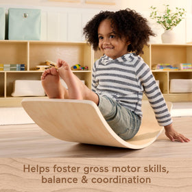 Fisher-Price Wood Montessori Rockin' Balance Board child at play captures dynamic movement and fun.