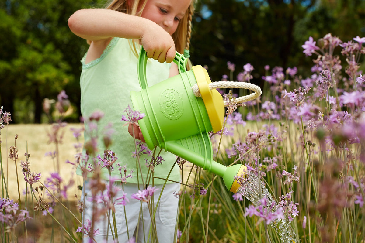 Green Toys Watering Can set with rake and shovel enhances imaginative outdoor learning.