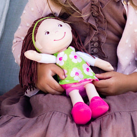 HABA Coco doll with removable green dress, perfect for dress-up play.