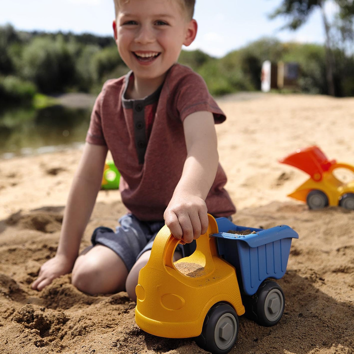 HABA kids playing sand with dump truck enjoying creative outdoor fun.