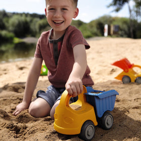 HABA kids playing sand with dump truck enjoying creative outdoor fun.