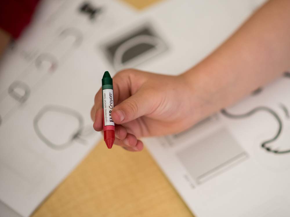Handwriting Without Tears color-in-action shot highlights vibrant colors and flipping fun.