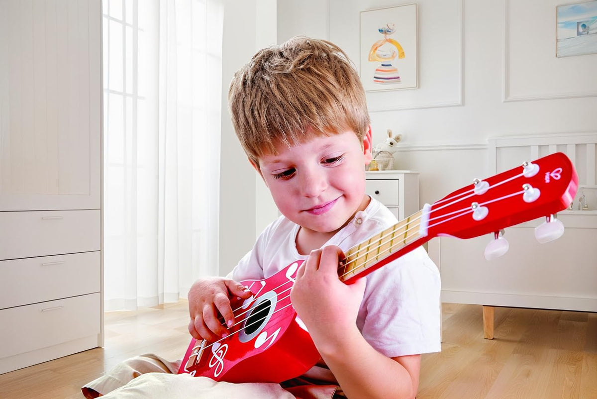 Hape ukulele red, side view, sturdy wood for creative play