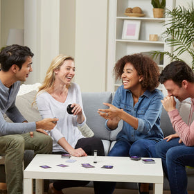 Hasbro Gaming Midnight Taboo group laughs during fast clues.
