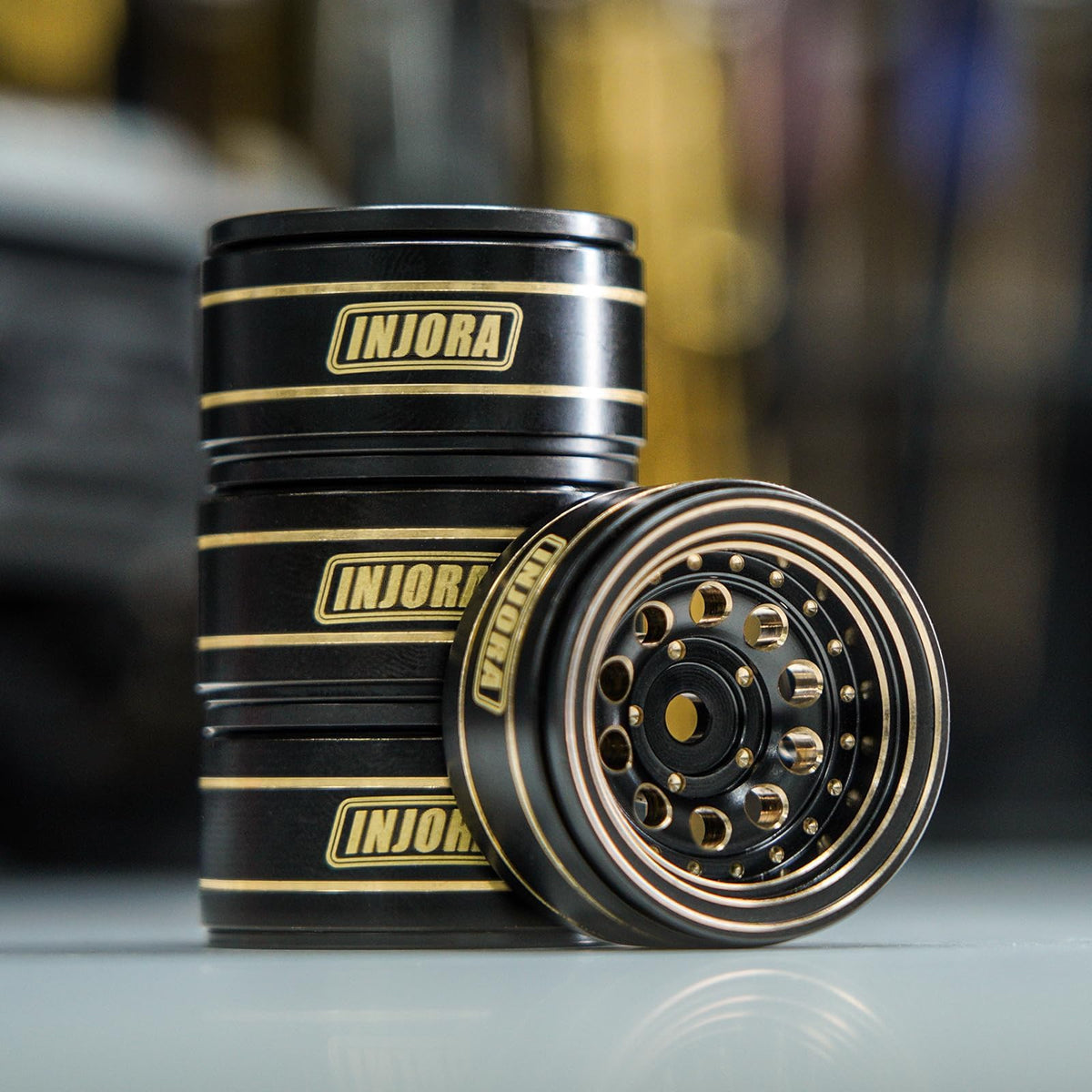 Close-up of INJORA brass wheel showing durable coating and brass texture.