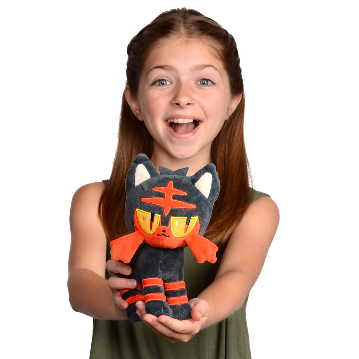 Litten plush on a bed, a cozy nighttime companion.