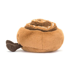 Jellycat Amuseables Cinnamon Bun sitting pose beside shelf for easy display and play.