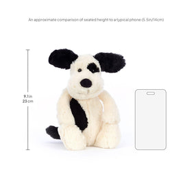 Jellycat Bashful Black & Cream Puppy held by a child for comforting hugs
