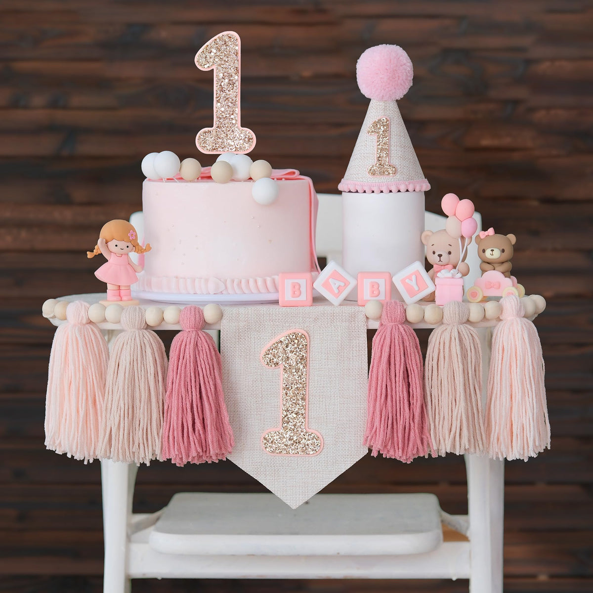 JUIIZAY pink first birthday banner over a high chair for sweet photos.