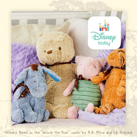 Child holding Pooh plush, a comforting travel companion on trips.