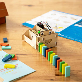 KiwiCo Domino Machine contents show 100 wooden dominoes for imaginative runs.