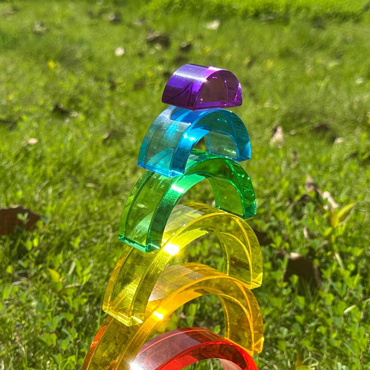 KOAICS child playing rainbow stackers encourages imaginative building and sensory exploration.