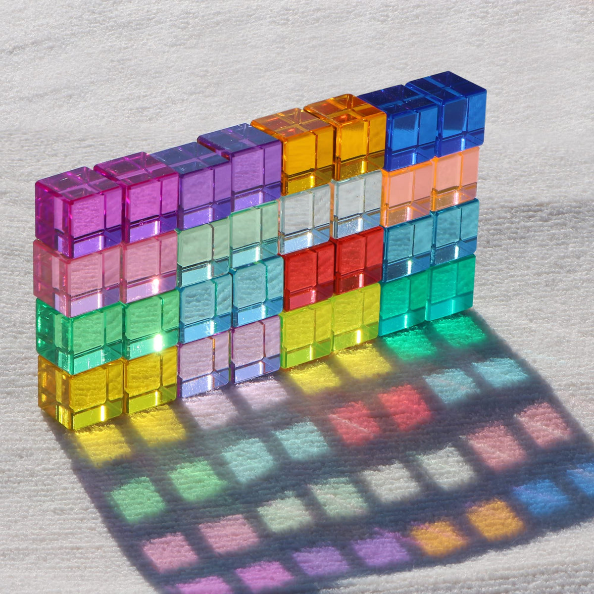 KOAICS Rainbow Crystal Cubes on a light table create luminous color shadows for sensory play.